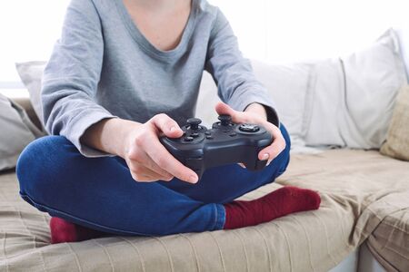 Man holding a joystick controllers while playing a video games at home