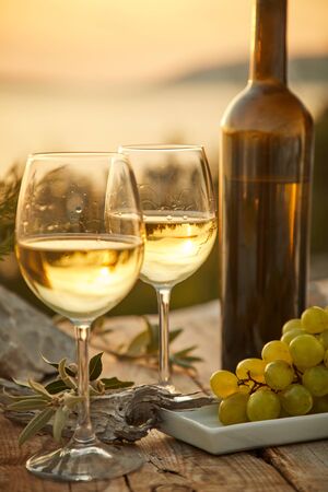 two glasses with wine during sunset timeの写真素材