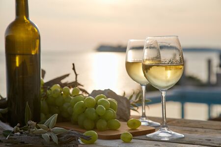 two glasses with wine during sunset timeの写真素材