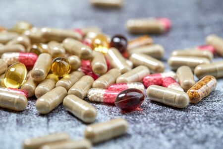 Medicine pills and capsules on grey surface