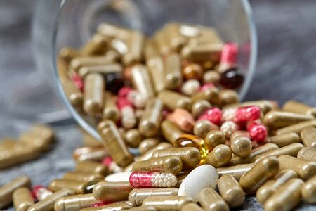 Medicine pills and capsules on grey surface