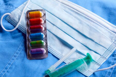 Pharmaceutical medicine tablets, pills, capsules and medical mask on blueの写真素材