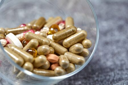Medicine pills and capsules on grey surface