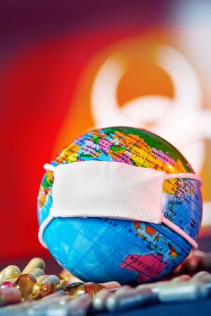 concept, globe in a protective mask on alarm background, epidemic, danger of peaceの写真素材