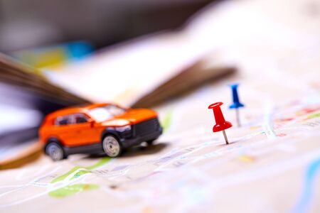 travel concept - small toy car on the mapの写真素材