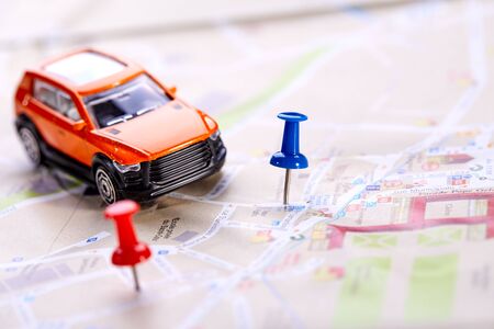 travel concept - small toy car on the mapの写真素材