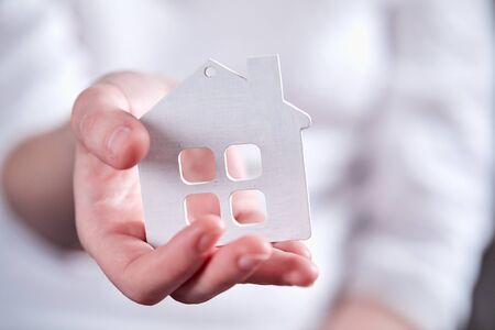 Female hands holding model of houseの写真素材