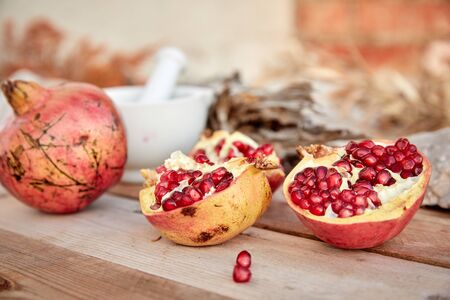 ripe organic pomegranate on teh wooden backgroundの写真素材
