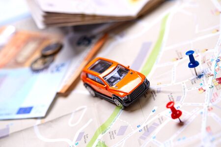 travel concept - small toy car on the mapの写真素材