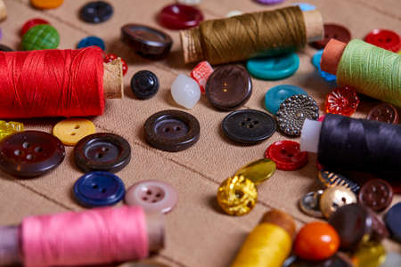 Background and texture of multicolored antique buttons and sewing tools