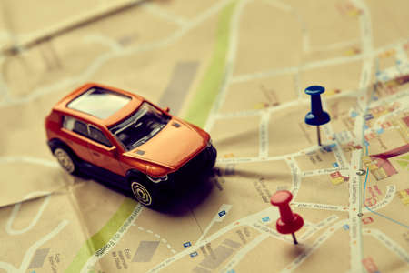 travel concept - small toy car on the mapの写真素材
