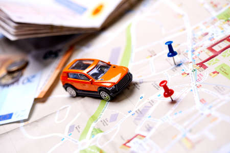 travel concept - small toy car on the mapの写真素材