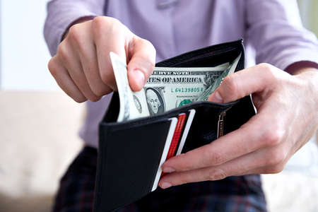 Man holding wallet with us dollars
