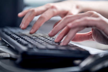 Female hands or woman office worker typing on the keyboardの写真素材
