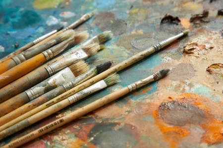 Tubes of oil paint, palette and artist paintbrushes closeup.の写真素材