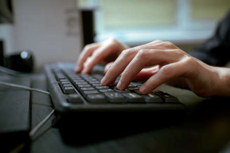 Female hands or woman office worker typing on the keyboardの写真素材