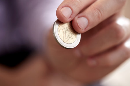Closeup of man hand holding coins isolated on white backgrounの写真素材