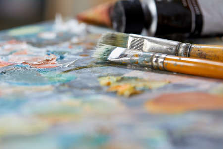 Tubes of oil paint, palette and artist paintbrushes closeupの写真素材