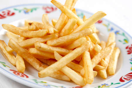 golden french fries on the wooden backgroundの写真素材