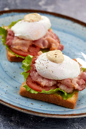 toasts with poached egg and baconの写真素材