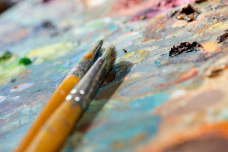 Tubes of oil paint, palette and artist paintbrushes closeupの写真素材
