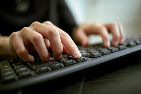 Female hands or woman office worker typing on the keyboardの写真素材