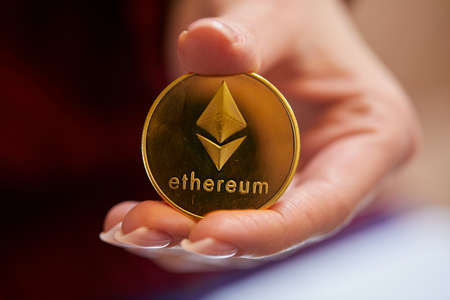 Hand holding golden bitcoin ethereumの写真素材