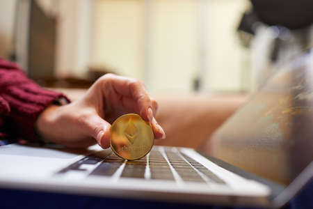 Hand holding golden bitcoin ethereumの写真素材