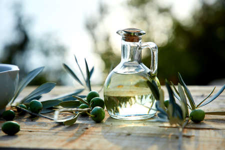 olive oil and green olive on the wooden backgroundの写真素材