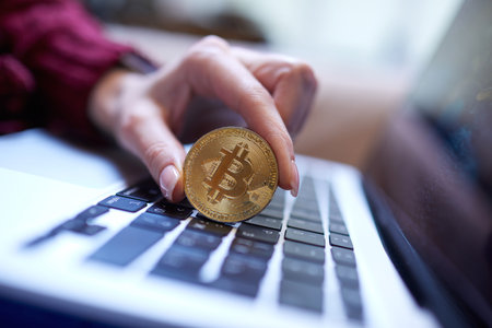 Hand holding golden bitcoin gold coinの写真素材