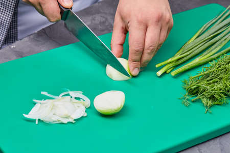 chef cutting onion on the kitchenの写真素材