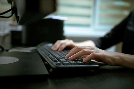 Female hands or woman office worker typing on the keyboardの写真素材