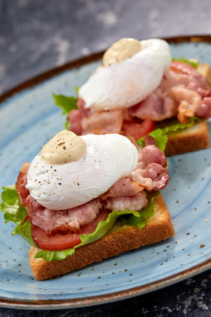 toasts with poached egg and baconの写真素材