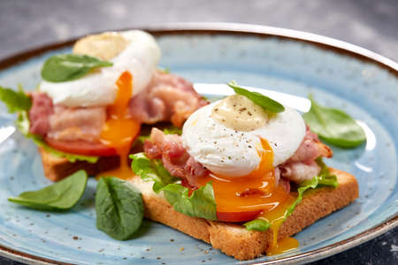 toasts with poached egg and baconの写真素材