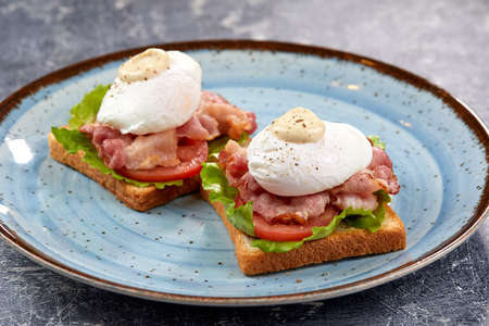 toasts with poached egg and baconの写真素材