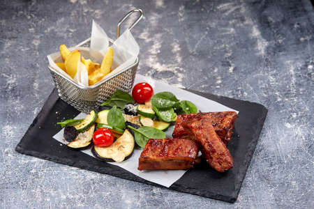 grilled ribs with french fries and vegetablesの写真素材