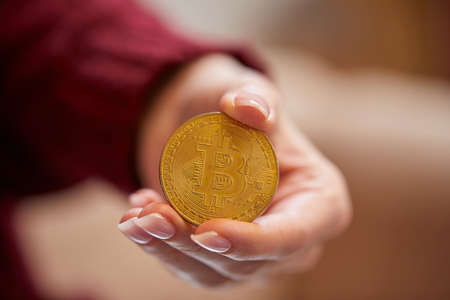 Hand holding golden bitcoin ethereum