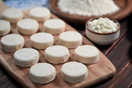 raw cottage cheese pancakes on the wooden boardの写真素材