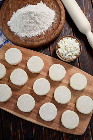 raw cottage cheese pancakes on the wooden boardの写真素材