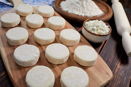 raw cottage cheese pancakes on the wooden boardの写真素材