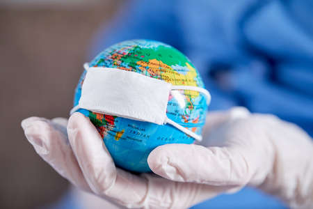 doctor holding globe with protective maskの写真素材