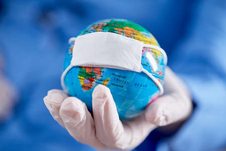doctor holding globe with protective maskの写真素材