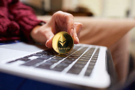 Hand holding golden bitcoin ethereumの写真素材