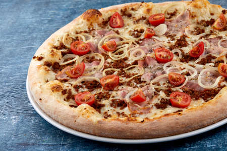 pizza with meat and cherry tomatoの写真素材