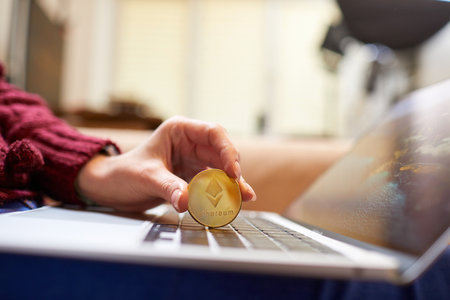 Hand holding golden bitcoin ethereumの写真素材