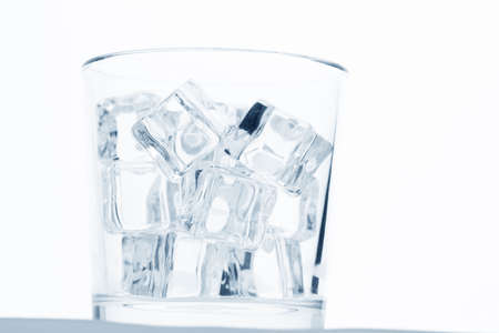 glass with ice cubes on whiteの写真素材