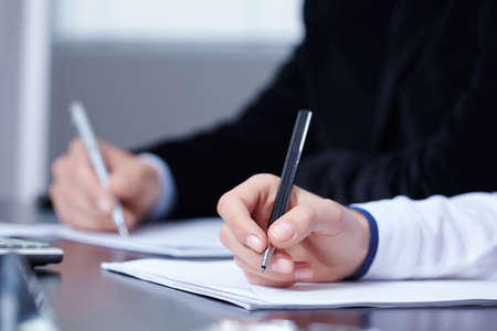 man and woman hands signing contract paper in officeの写真素材
