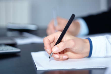 man and woman hands signing contract paper in officeの写真素材