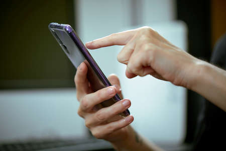 woman holding smartphone in officeの写真素材