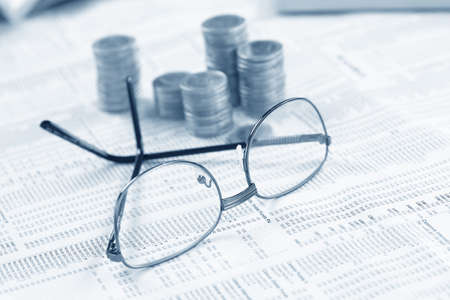 glasses and coins on the tableの写真素材